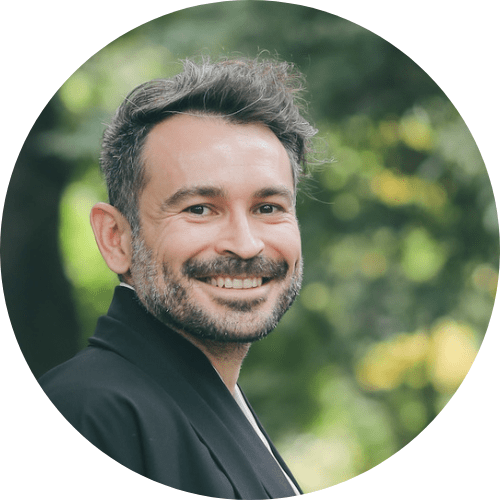 A man smiling in kimono in a green background